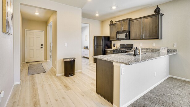A modern kitchen with wooden cabinets, a granite countertop, and stainless steel appliances. - Hike, Sightsee & Explore: Home in Colorado Springs (Colorado Springs)