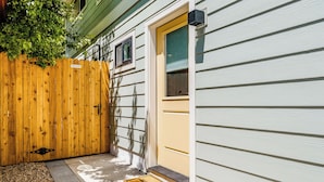A house with a wooden fence, a yellow door, and a welcome mat. - < 1 Block to City Park: New-build Apt in Denver! (Denver)