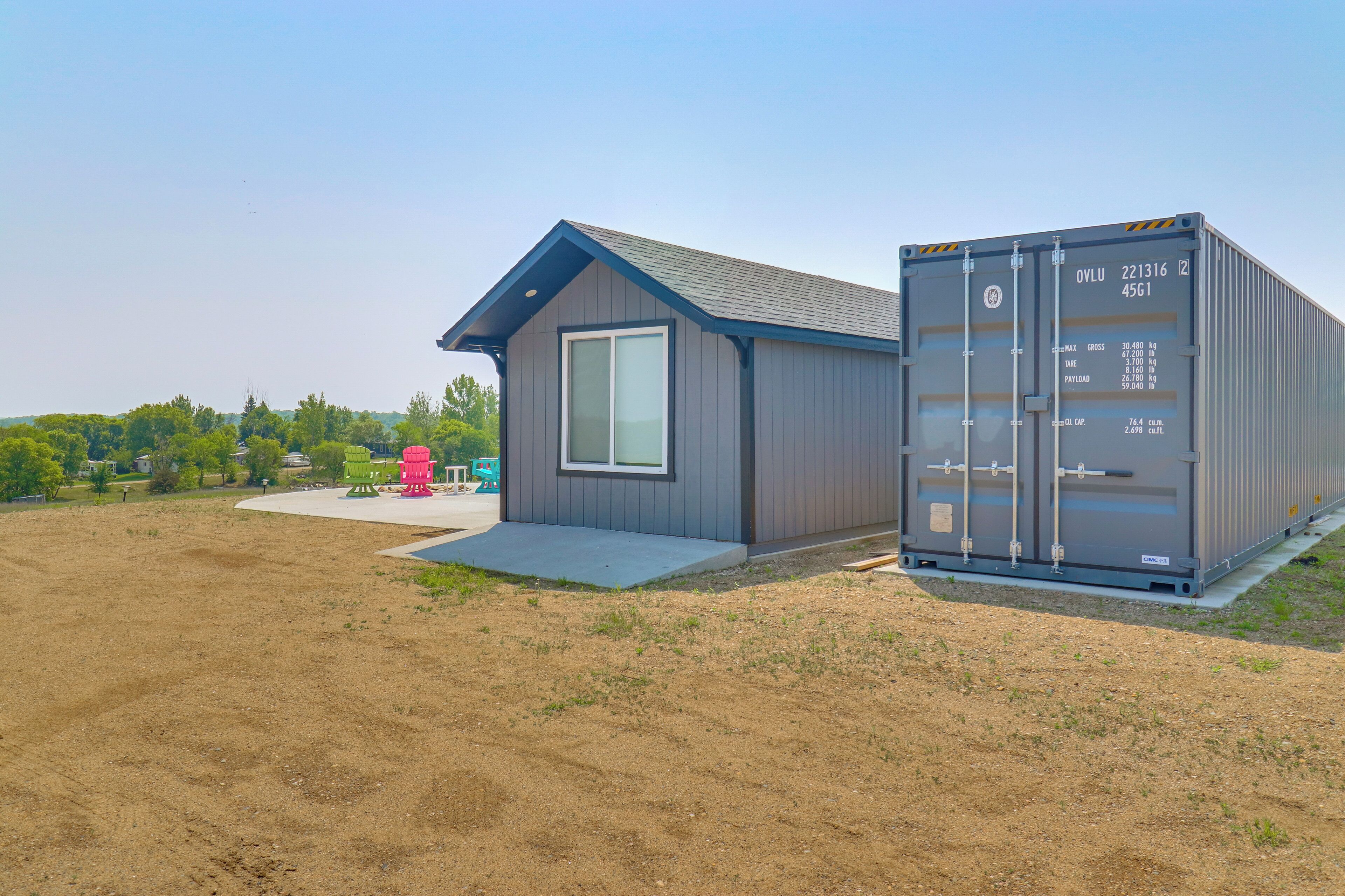 A modern building with a small porch and a shipping container attached.