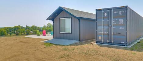 A modern building with a small porch and a shipping container attached.