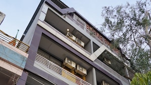 A multi-story building with a sign for "Hotel Suryodaya" and a pharmacy sign. - Hotel Suryodaya (Ujjain)