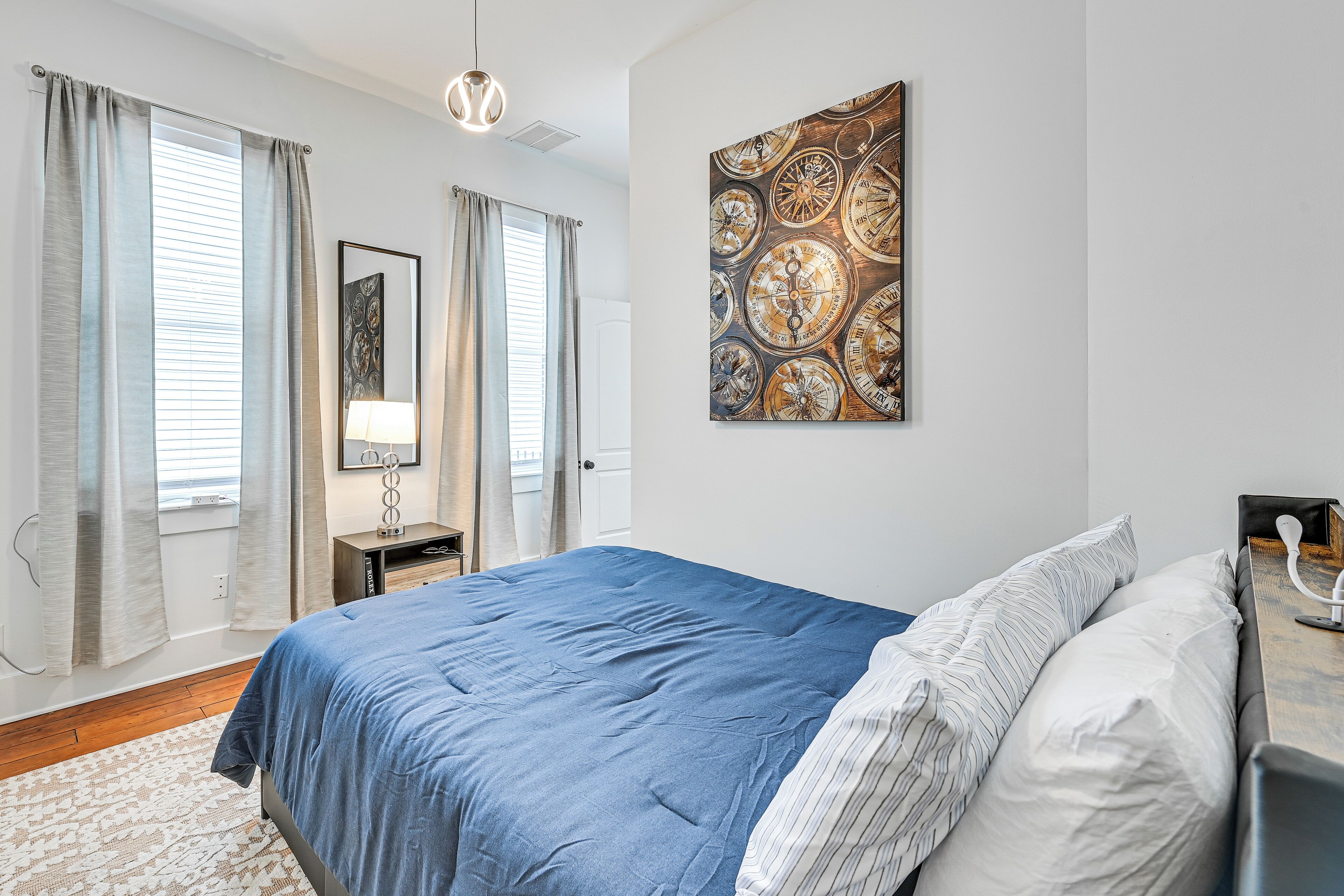 Una camera da letto con un letto grande, un comodino, una lampada e un'opera d'arte appesa al muro.