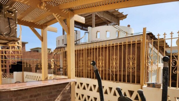A covered outdoor area with a pergola, a metal gate, and exercise equipment. - Villa Yanny Duplexes Apartment Hurghada El Dahar El Helal (Hurghada)