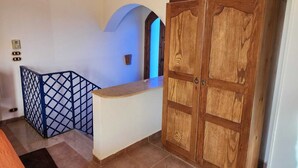 A room with a wooden wardrobe, a blue-framed staircase, and a tiled floor. - Villa Yanny Duplexes Apartment Hurghada El Dahar El Helal (Hurghada)