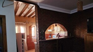 A kitchen with a brick wall, a wooden counter, and a hanging light fixture. - Villa Yanny Duplexes Apartment Hurghada El Dahar El Helal (Hurghada)