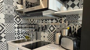 Une cuisine compacte équipée d’un lave-linge, d’un four à micro-ondes, d’un grille-pain et d’une bouilloire.