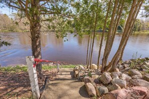 A concrete staircase leading down to a body of water, surrounded by rocks and trees.