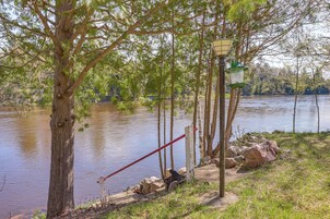 Escena junto al lago con un poste de madera, una farola y un poste rojo.