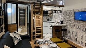 A compact living space with a loft bedroom, kitchenette, and a dining area. - Loft Jaures (París)