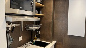 A modern kitchen with a built-in oven, microwave, and stainless steel range hood.