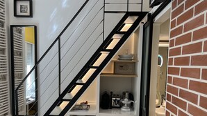 A modern kitchen with a built-in refrigerator, a coffee machine, and a small shelf with kitchenware.