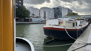 Un barco amarrado en un puerto con un paisaje urbano al fondo.