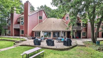 A red building with a covered patio area, outdoor seating, and a picnic table.