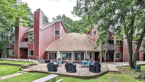 A red building with a covered patio area, outdoor seating, and a picnic table.