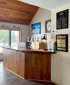 Un mostrador de recepción de madera con un cartel que dice "LAKE" y un reloj encima.