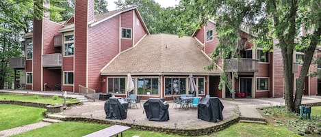 A red building with a covered patio area, outdoor seating, and a picnic table.
