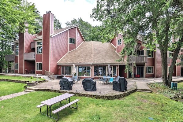 A red building with a covered patio area, outdoor seating, and a picnic table.