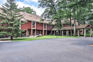 Een meerlaags gebouw met een overdekte ingang en een parkeerplaats.