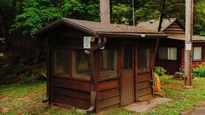 A small wooden cabin with a sloped roof, large windows, and a door. - Old Stoney's Walleye- PET FRIENDLY (Arbor Vitae)
