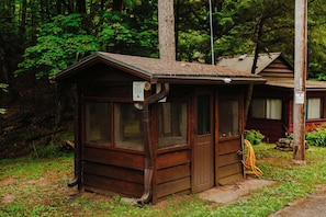 A small wooden cabin with a sloped roof, large windows, and a door.