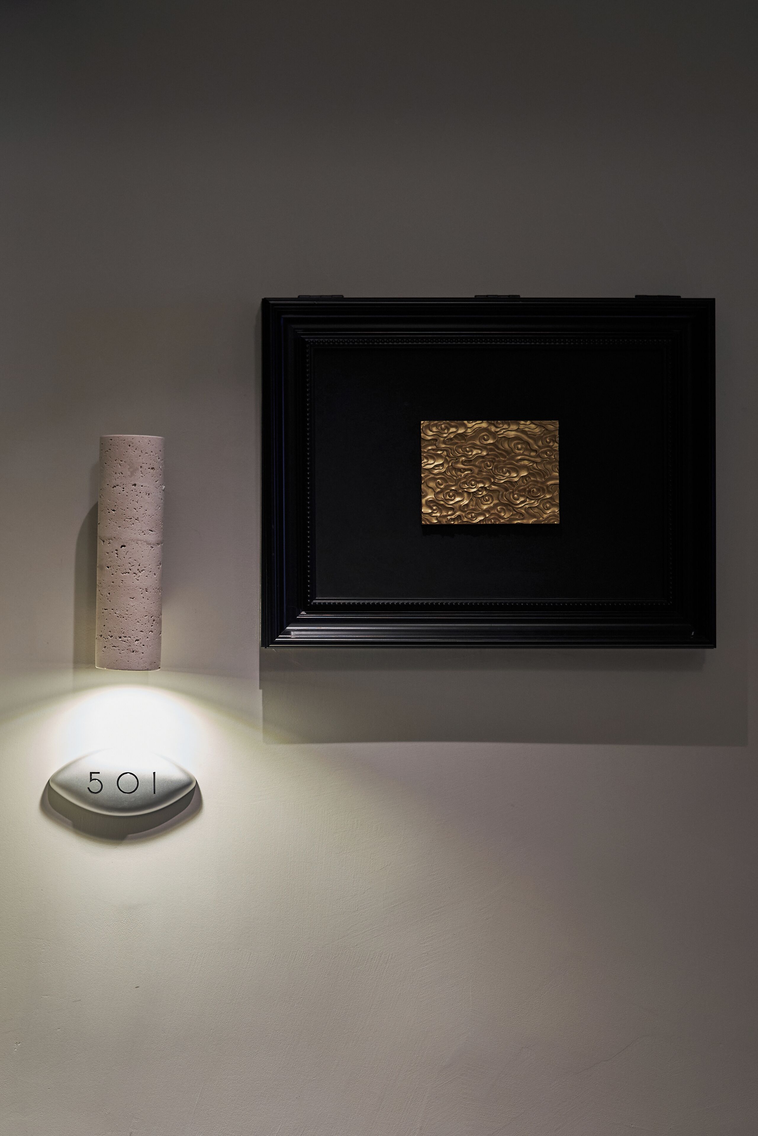 Una obra de arte enmarco con un fondo dorado texturizado, un florero rosa texturizado y un cartel iluminado.