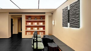 A modern interior with a skylight, a bookshelf with decorative items, and a seating area with a unique black and brown design. - The Nest 1219 (Huangshan)