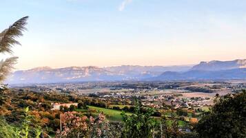 A panoramic view of a town nestled in a valley with mountains in the background.