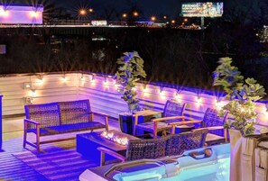 An outdoor seating area with a pool, lounge chairs, and a fire feature.