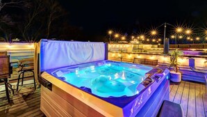 A hot tub with a wooden deck and outdoor lighting. - Expansive 4BR/5BA DT Home with Hot Tub & Game Room (Nashville)