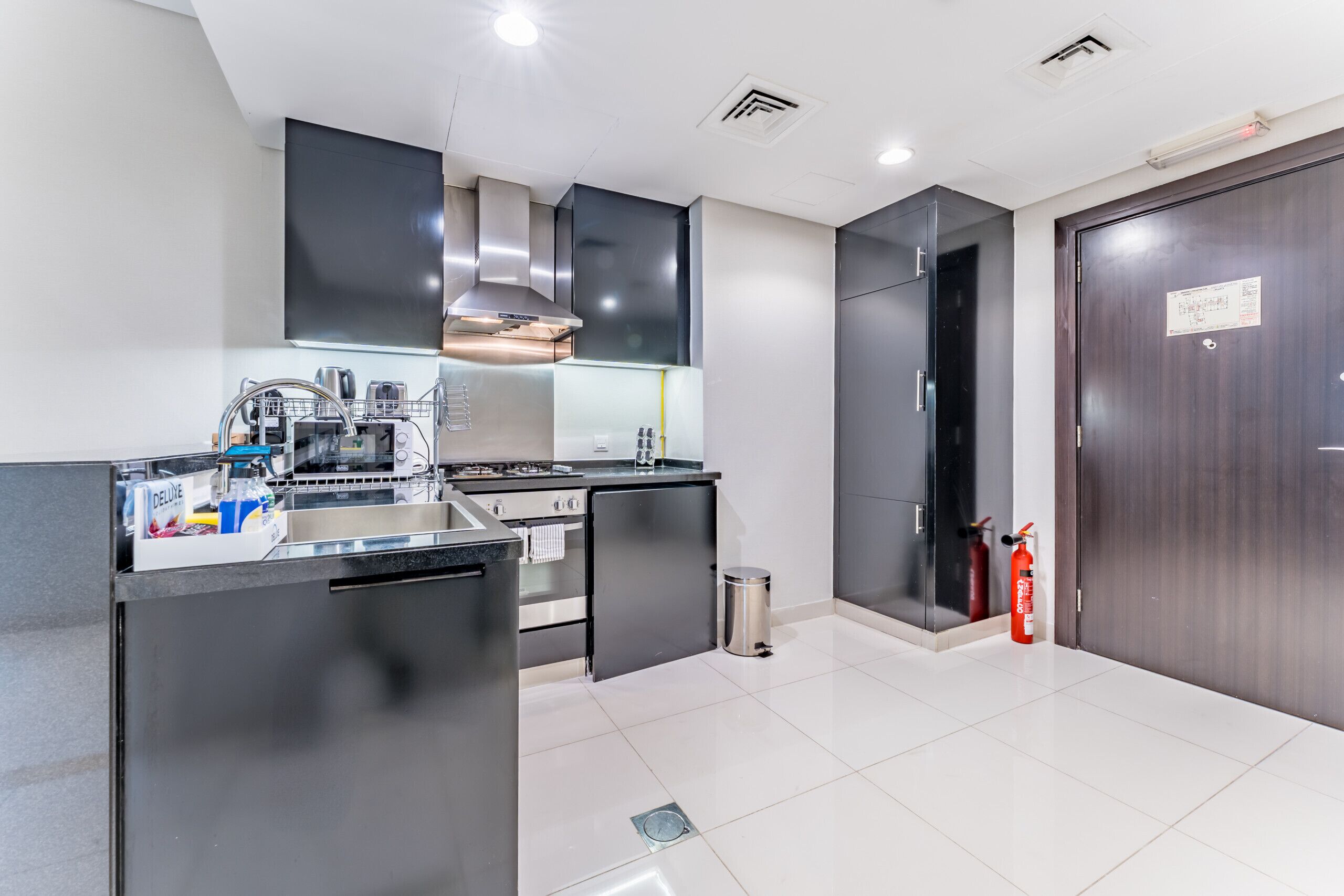 A modern kitchen with stainless steel appliances, a built-in oven, and a large island.