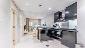 Una cocina moderna con una isla central, electrodomésticos de acero inoxidable y vistas al área de estar.