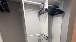 A walk-in closet with open shelving, a hanging rod, and a shoe rack.