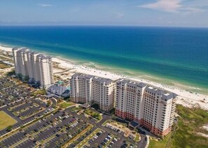 A high-rise hotel with multiple floors, a parking lot, and a beachfront view. - Beach Club Bristol 101 3 Bedroom Condo (Gulf Shores)