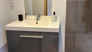 Een haardroger, handdoeken, zeep, toiletpapier