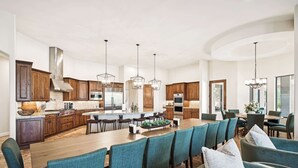 A spacious kitchen with wooden cabinets, a large island, and modern pendant lighting. - Scottsdale Rose Sleeps 40 Pool Pickleball Rooftop (Scottsdale)