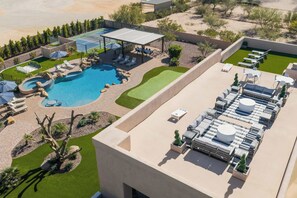 An aerial view of a resort with a swimming pool, sun loungers, a tennis court, and a covered seating area. - Scottsdale Rose Sleeps 40 Pool Pickleball Rooftop (Scottsdale)
