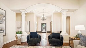 A spacious living room with two dark armchairs, a coffee table with a book, and a lamp on a side table. - Scottsdale Rose Sleeps 40 Pool Pickleball Rooftop (Scottsdale)