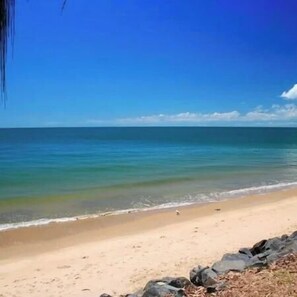 Una playa con agua azul cristalina y una orilla arenosa.
