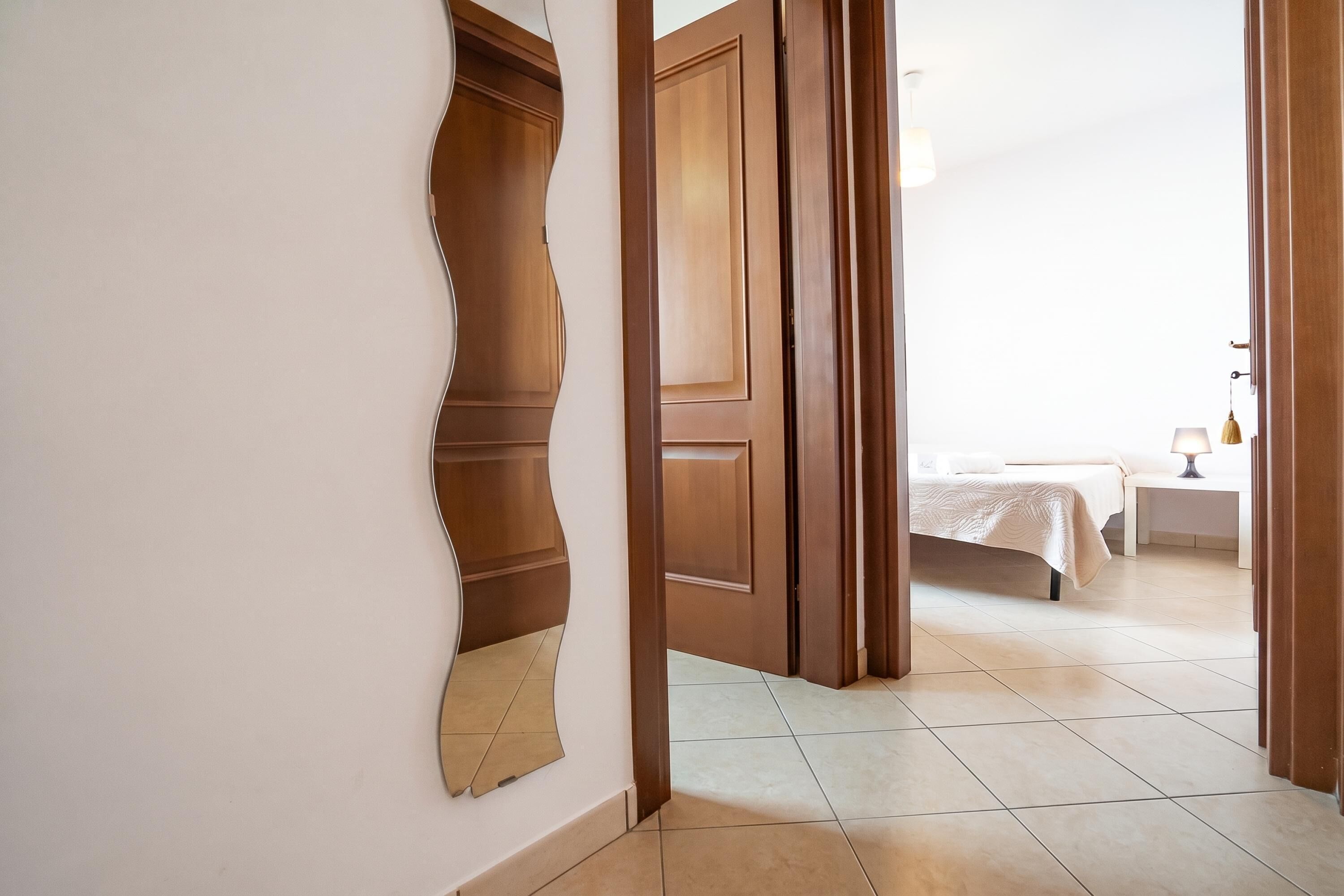 Una habitación de hotel con cama, mesita de noche y lámpara.