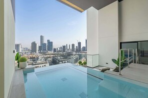 A modern rooftop pool with a city skyline view. - StayShort - Ultra-Luxury 2BR in JVC - Private Pool & Panoramic Skyline Terrace (JVC)