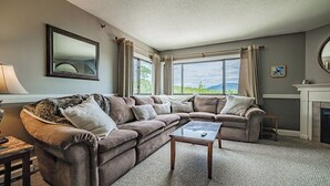A living room with a sectional sofa, a coffee table, and a fireplace. - Two bedroom North Peak Condo (Newry)