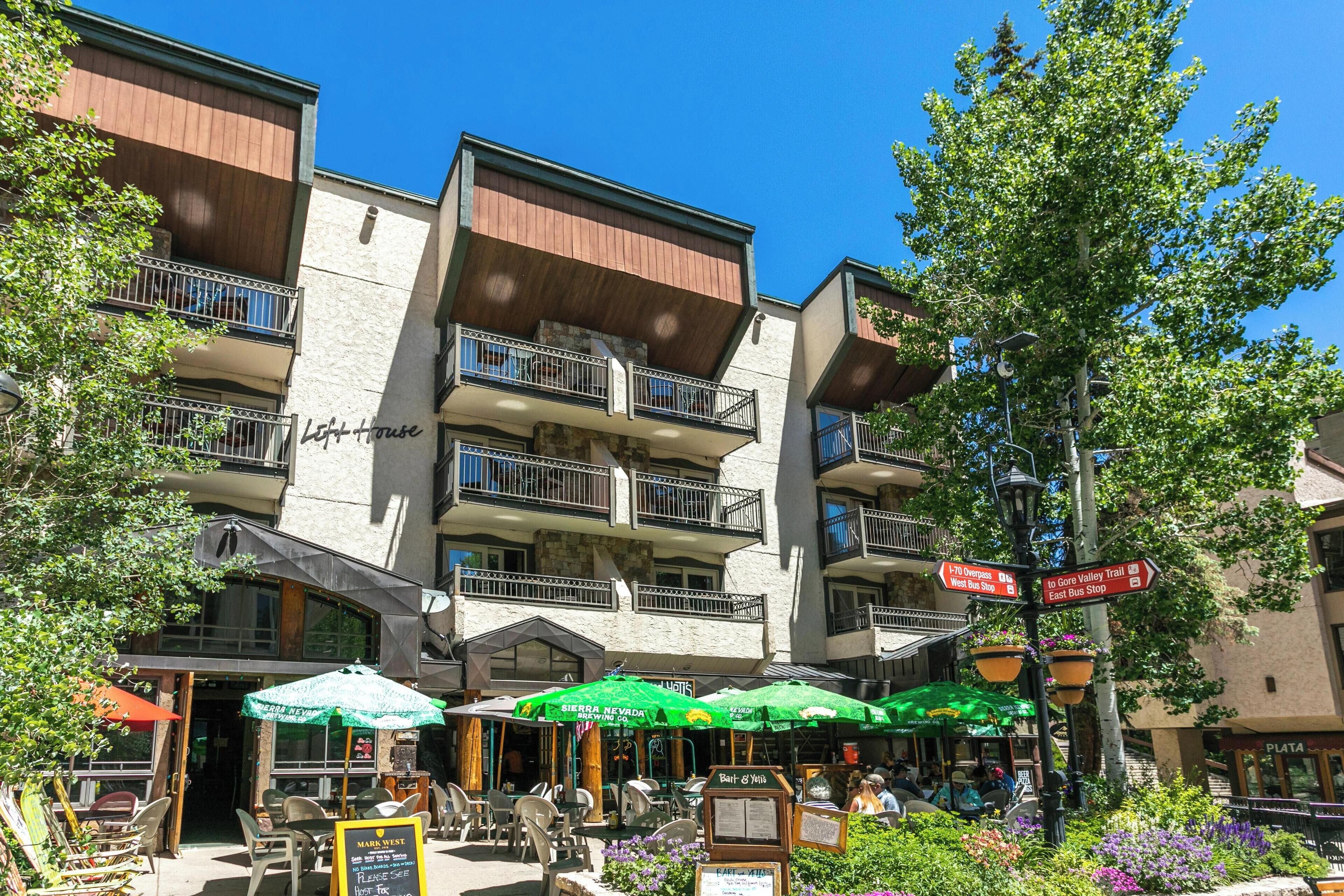 Un hotel con mesas al aire libre, un letrero que dice 'Sierra Nevada Brewing Co.' y un cartel que indica 'Left + House' en el edificio.