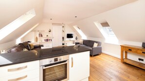A modern loft apartment with a kitchen, dining area, and living space. - JOIVY Modern flats near Edinburgh Castle (Edinburgh)