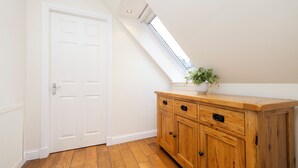 A room with a white door, wooden cabinet, and a skylight. - JOIVY Modern flats near Edinburgh Castle (Edinburgh)