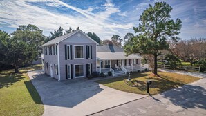 A two-story house with a front porch, a driveway, and a well-maintained lawn.