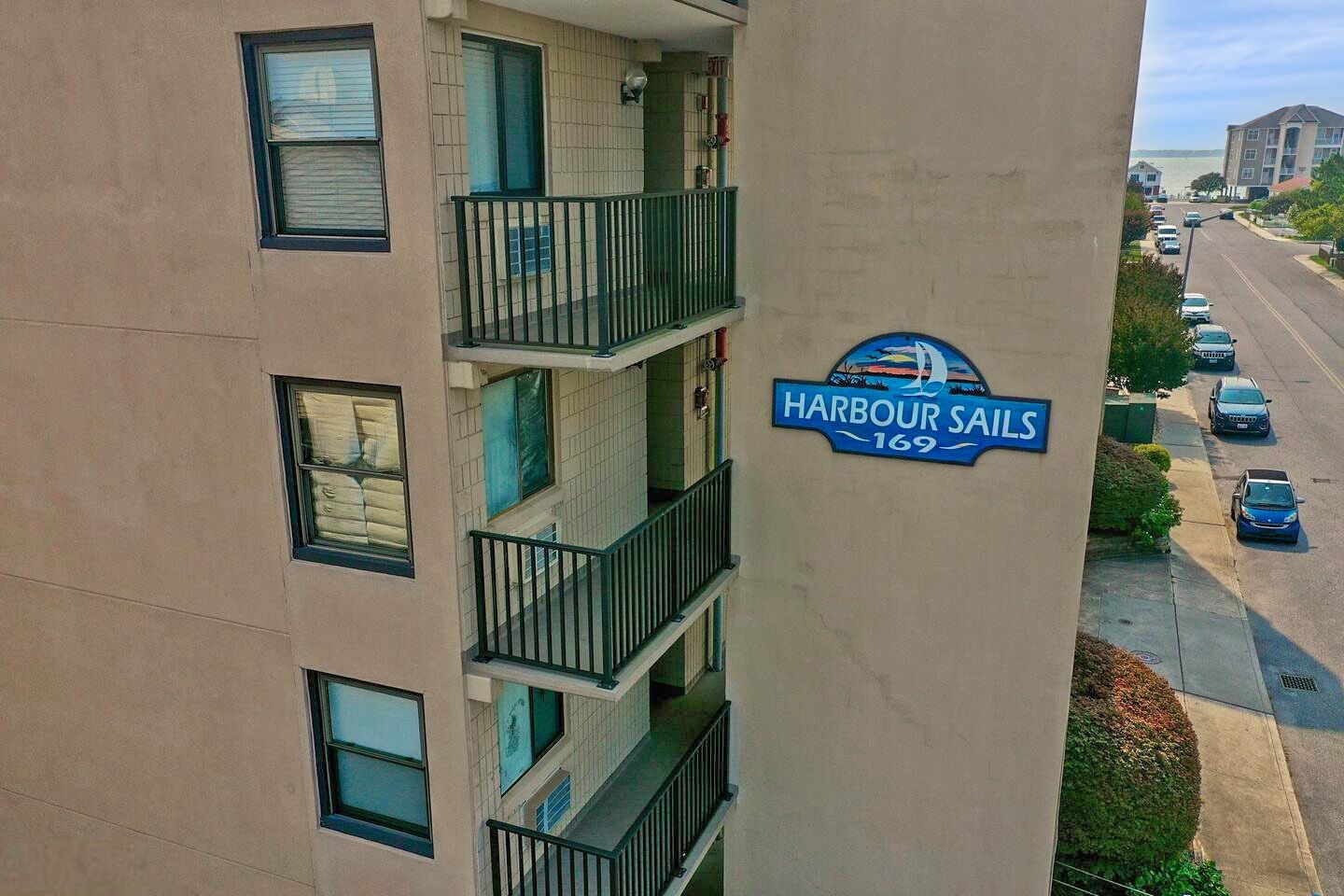 Un immeuble à plusieurs étages, sur lequel on peut lire l’inscription « Harbour Sails 169 » sur le côté.