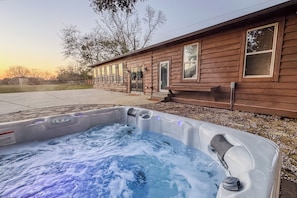 Una casa de madera con jacuzzi al frente.