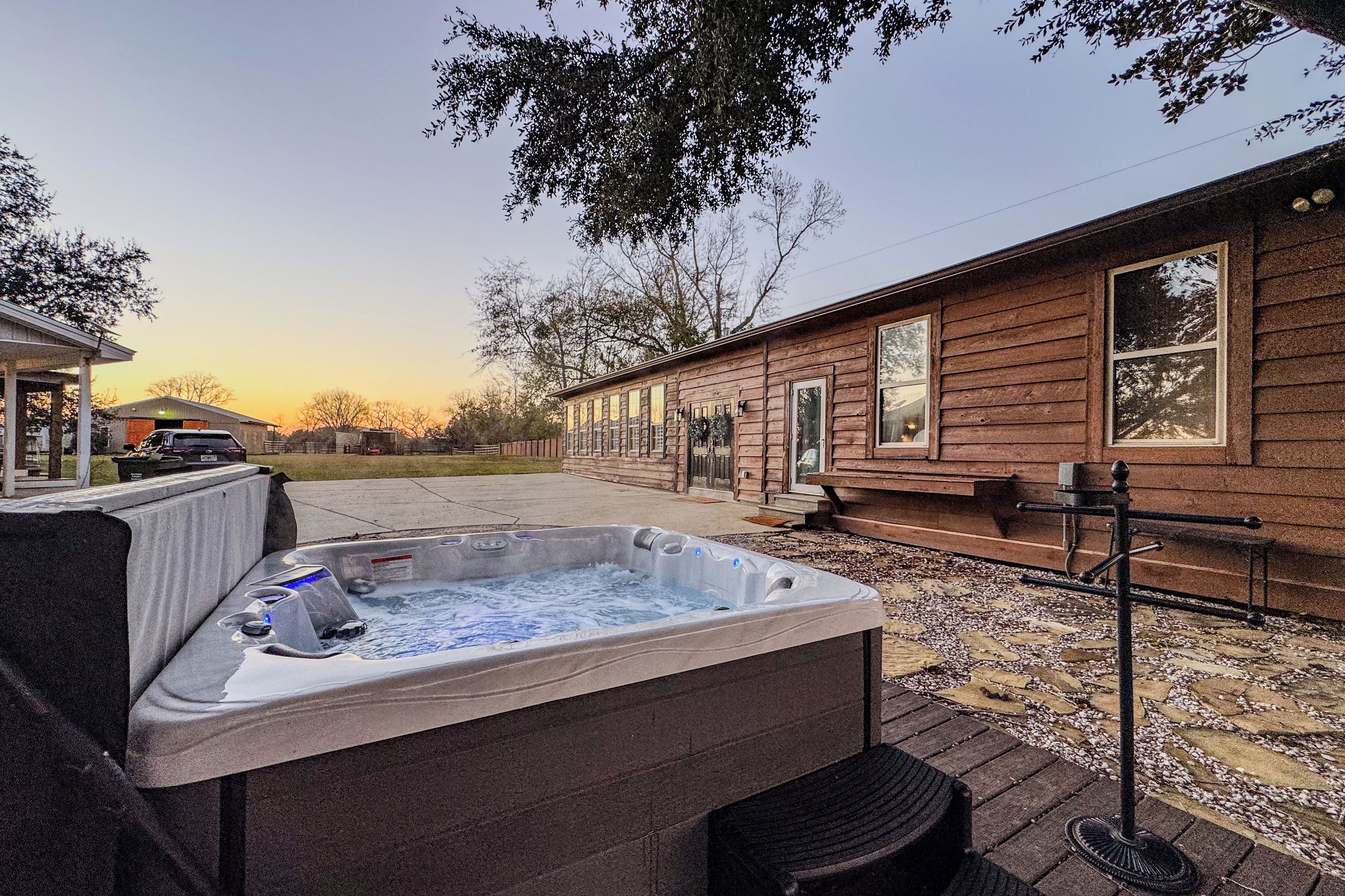 A wooden cabin with a hot tub and a covered seating area.