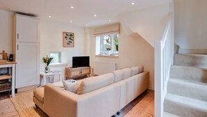 Una sala de estar moderna con un sofá, televisor y ventana con vistas.