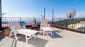 A terrace with white lounge chairs, a table, and a satellite dish. - Lucia Cottage BB (Massa Lubrense)